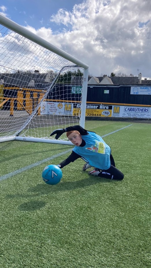 Young person playing football as goalkeeper