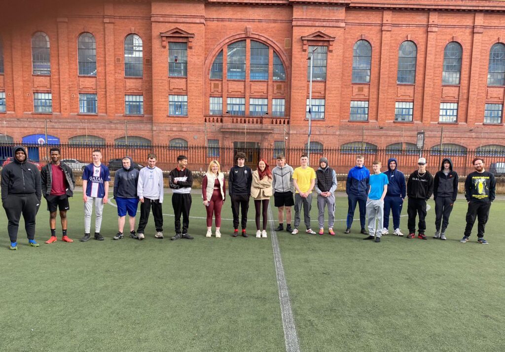 Group photo of young people in front of Ibrox Stadium.