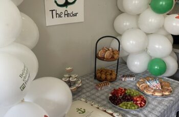 Image of balloons surrounding a table with cakes on.