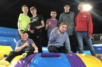 Group of young people at indoor inflatable assault course