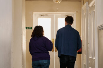 Two people walking down corridor